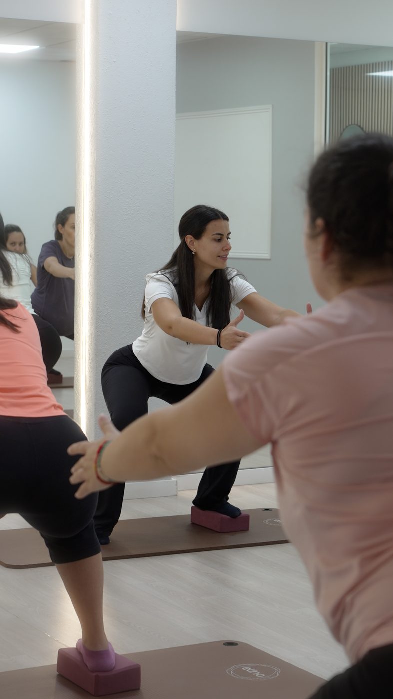 Fisioterapeuta a orientar de perto uma aluna de Pilates Clínico